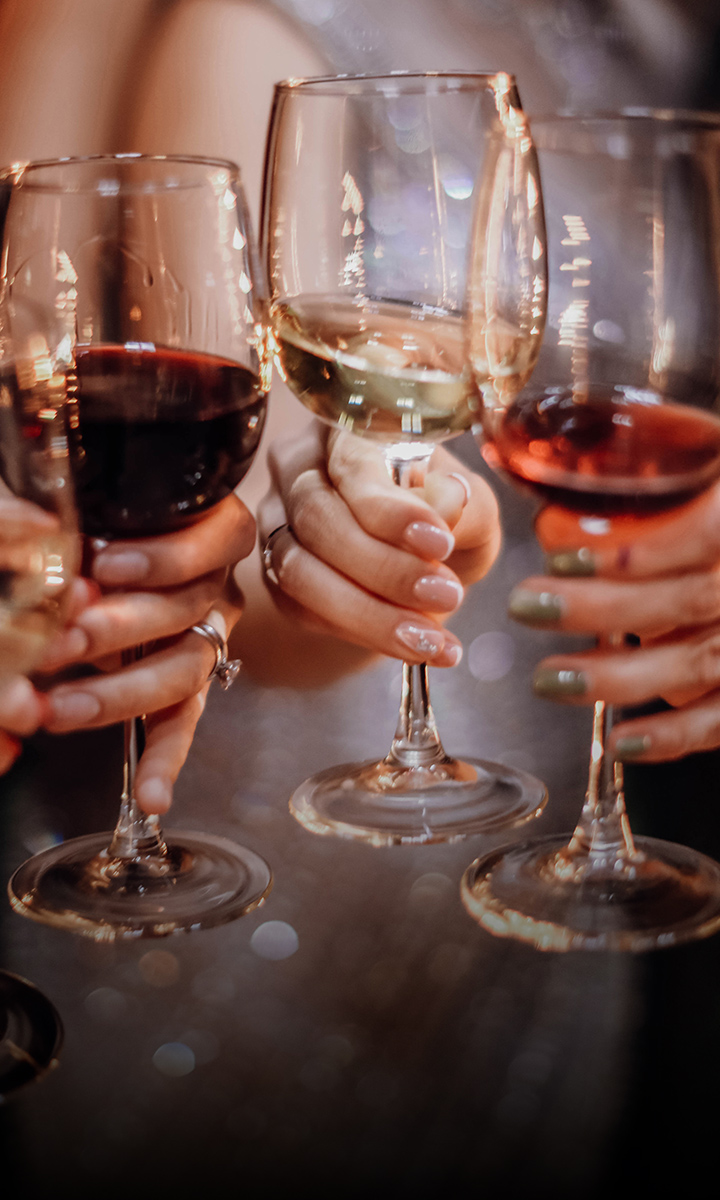 a group of hands holding wine glasses