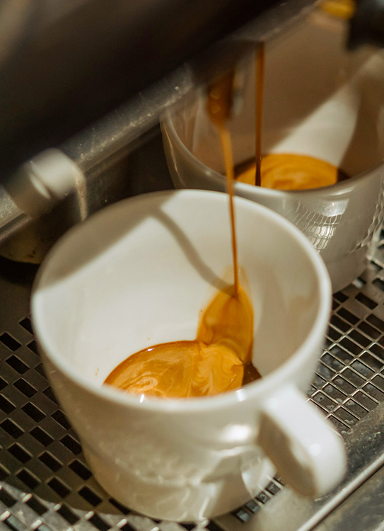 a coffee being poured into a cup