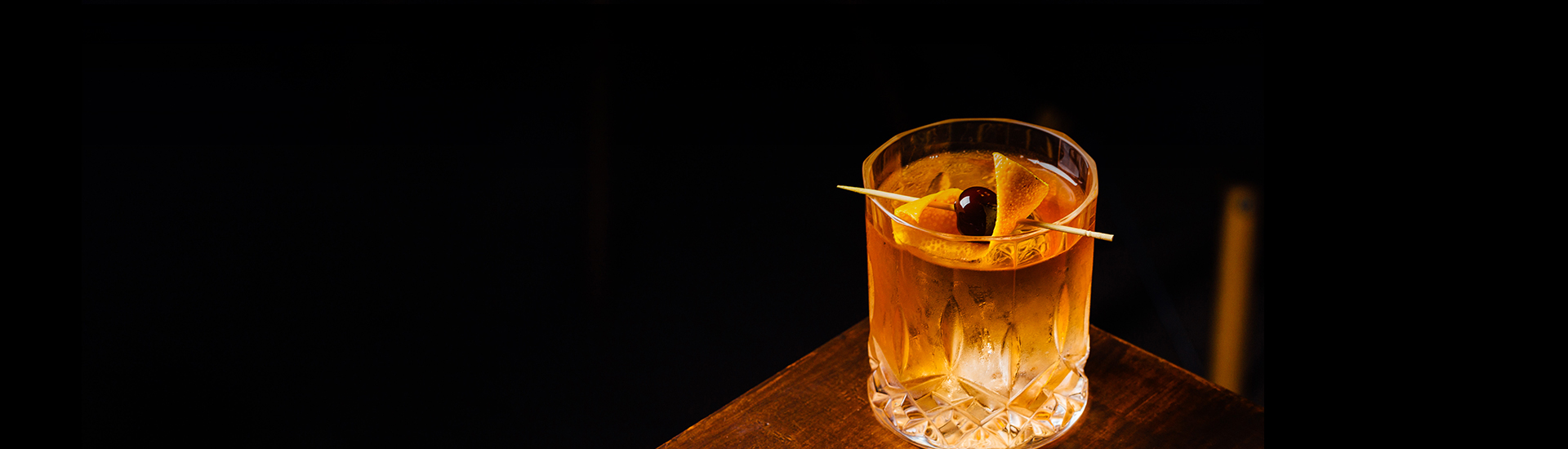 a glass with a drink and a cherry on top