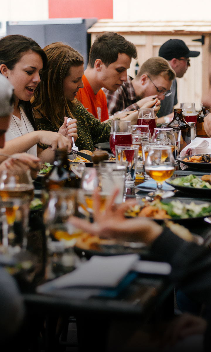 a group of people sitting at a table eating food