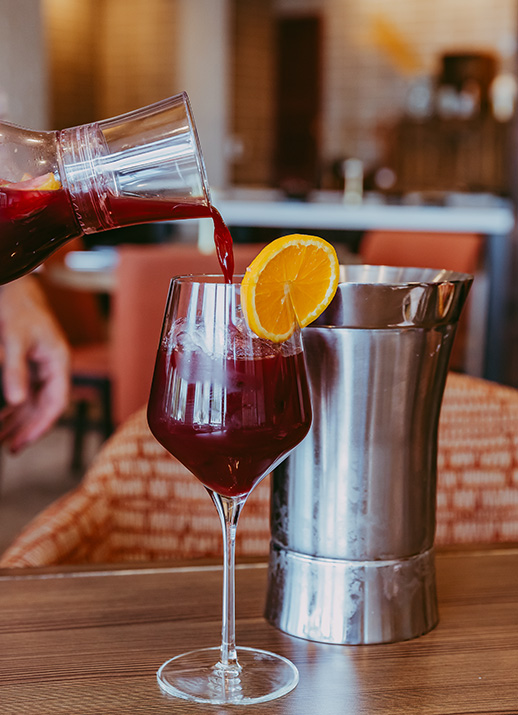a person pouring a drink into a glass