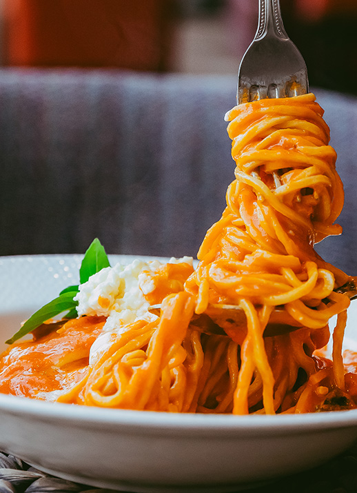 a fork on a plate of spaghetti
