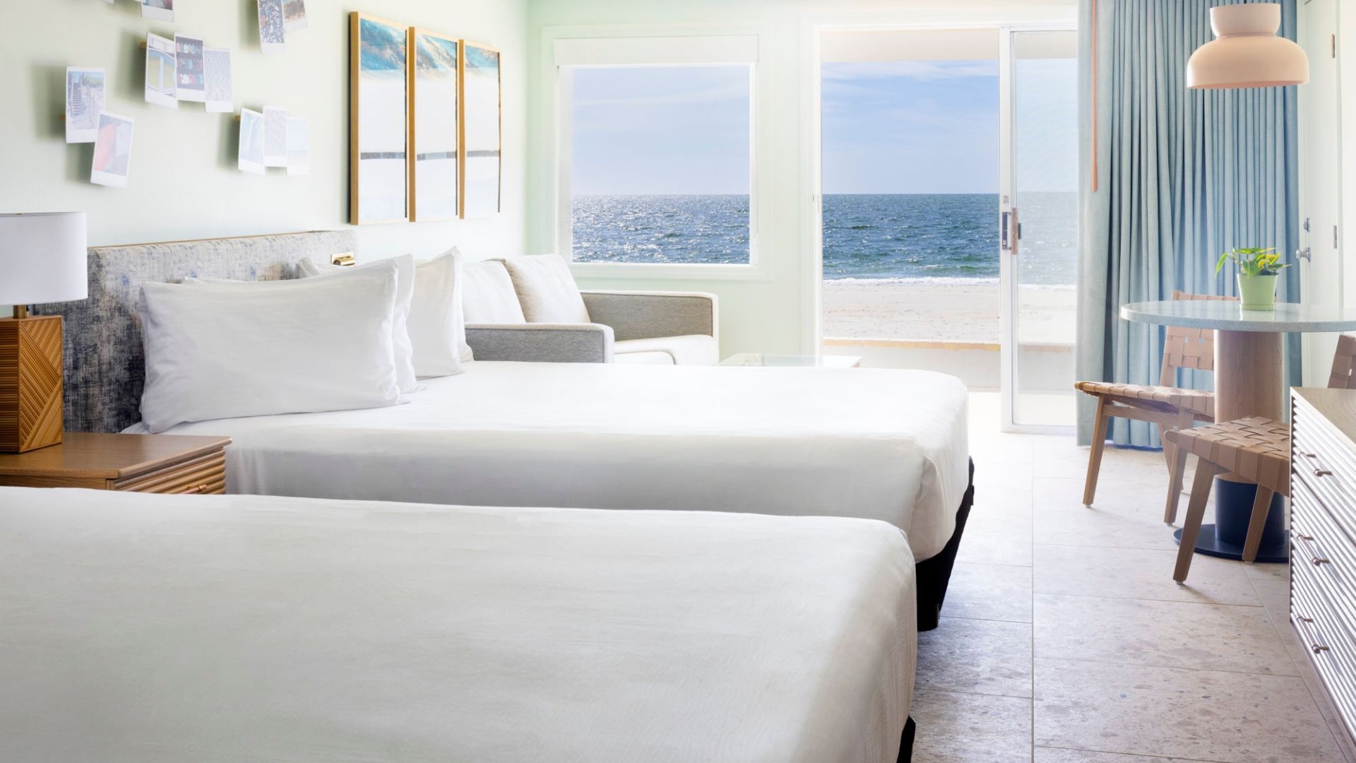 a room with two beds and a beach view