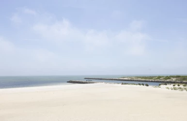 a beach with a body of water and a blue sky
