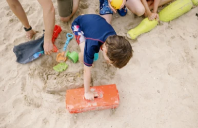 a group of children playing in the sand