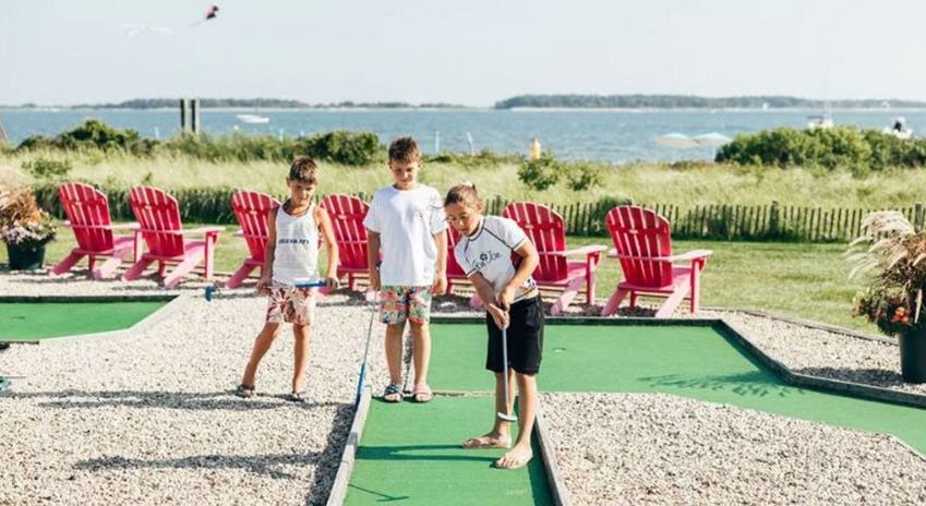 a group of kids playing mini golf