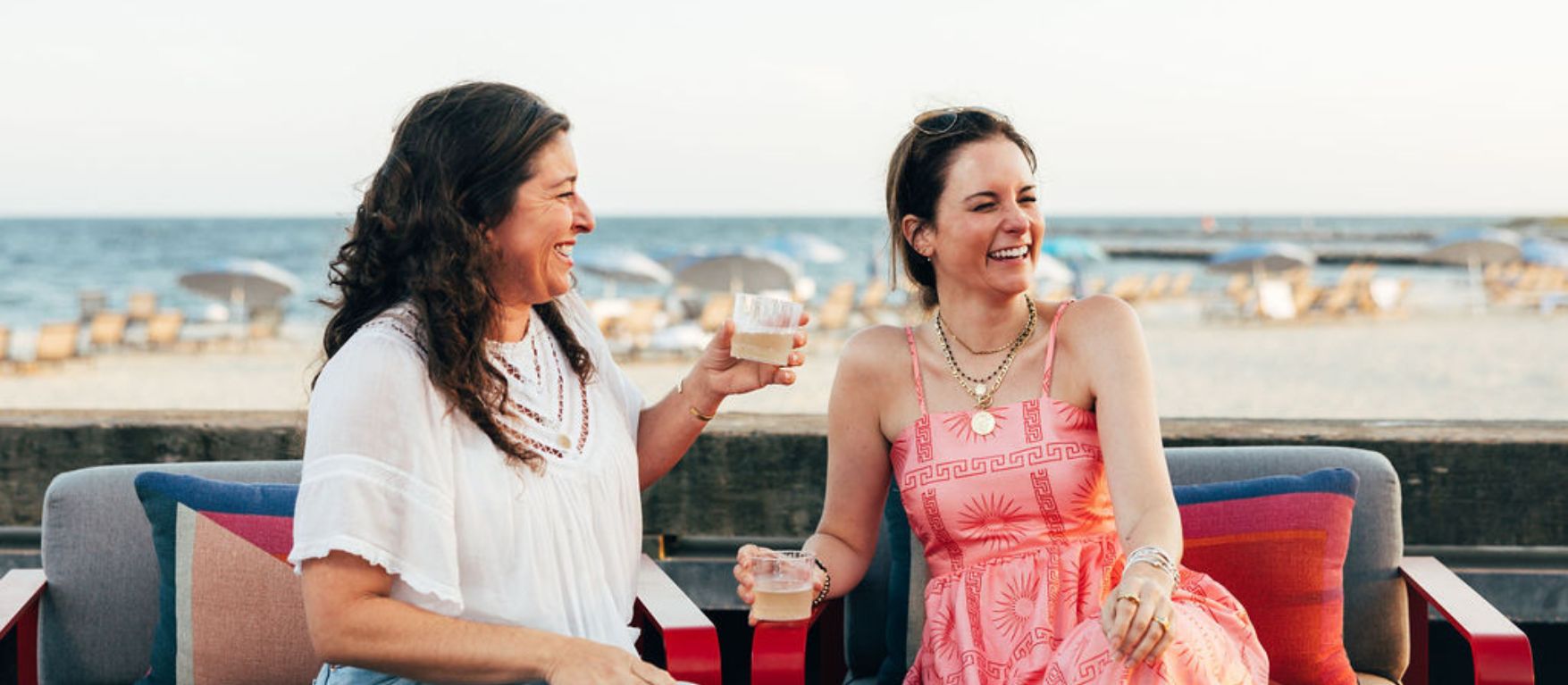 two women sitting on a bench and laughing