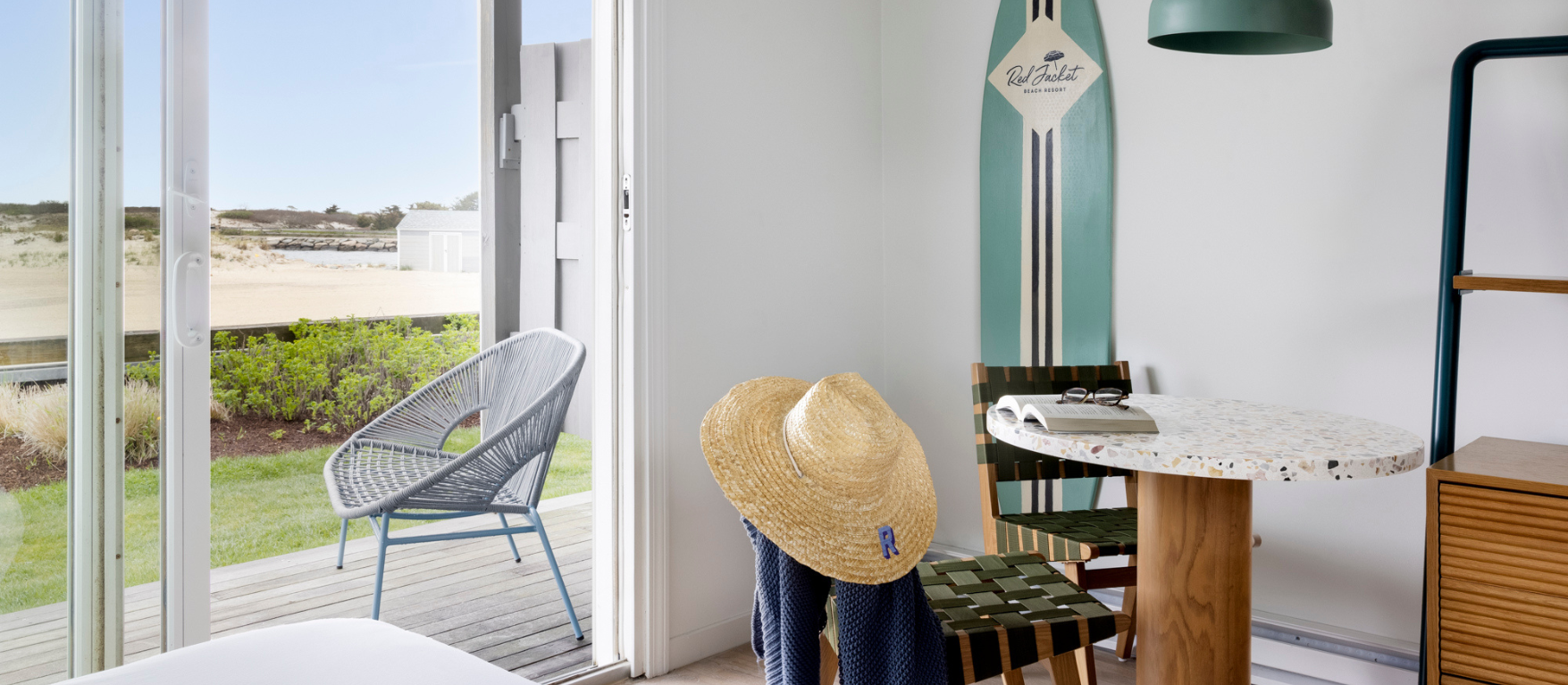 a room with a surf board and a table and chairs