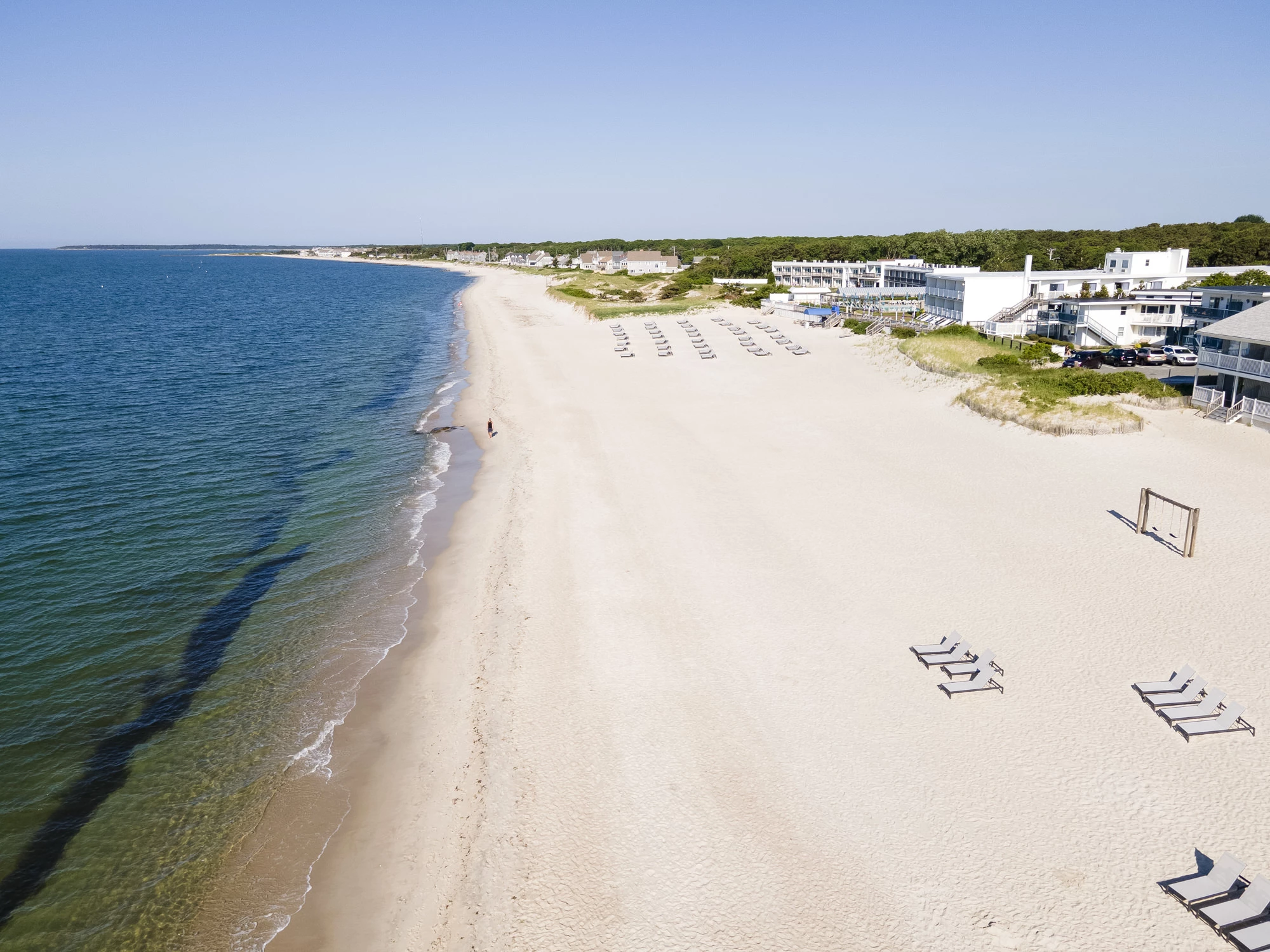 a beach with chairs and umbrellas