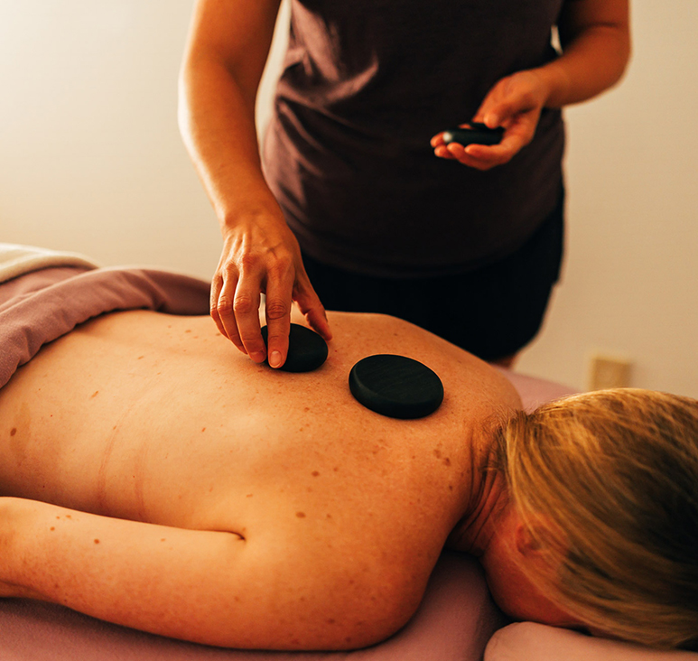 a person getting a massage with hot stones on their back