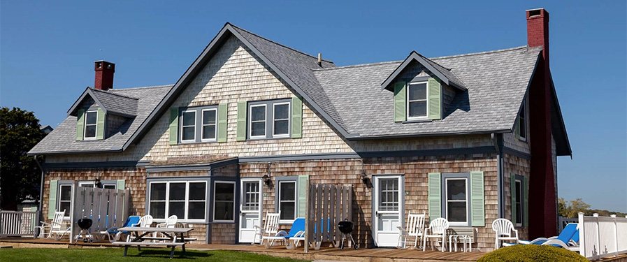 a house with lawn chairs and a grill