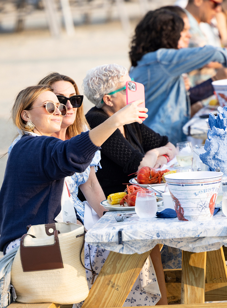 a group of women sitting at a table with food and drinks