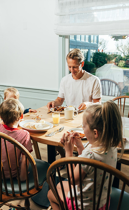 a man and kids eating at a table
