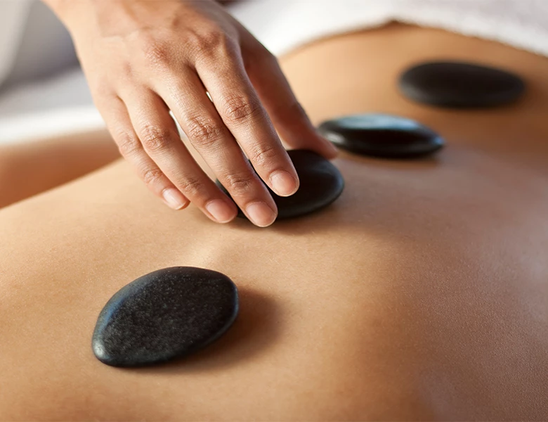 a person getting a hot stone massage