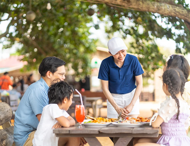 a woman serving food to a group of people