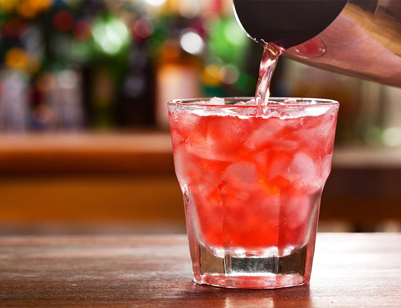 a glass with a drink and a red liquid