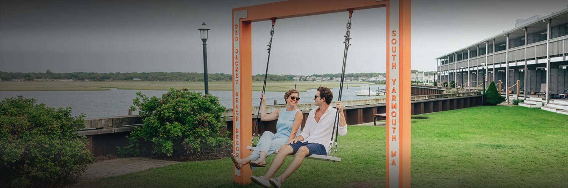 a man and woman sitting on a swing