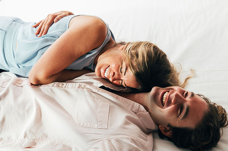 a man and woman lying on a bed