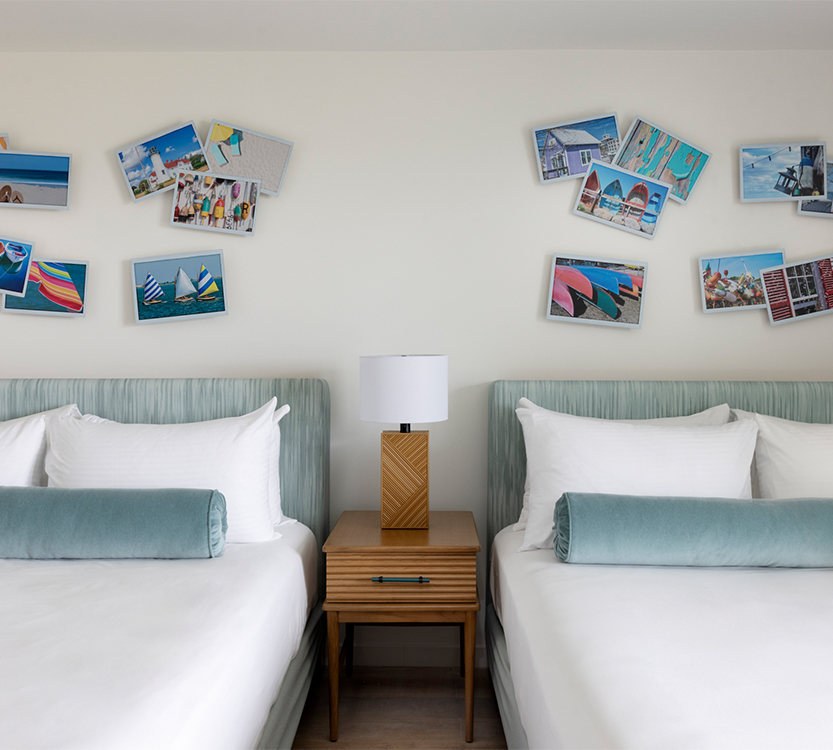 two beds with pictures on the wall