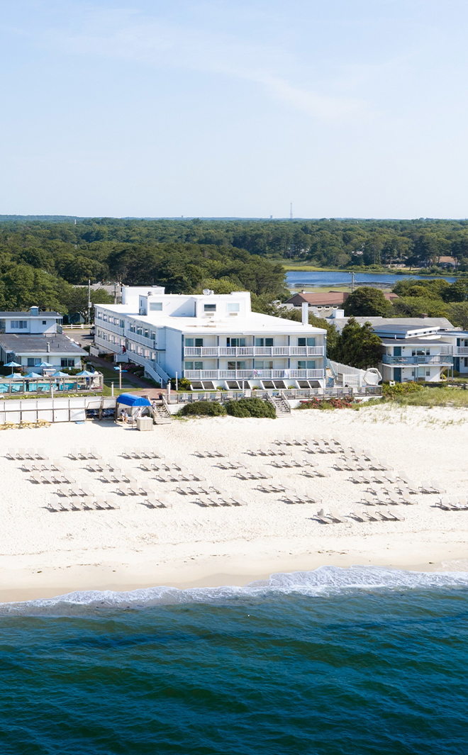 a beach with chairs and a building