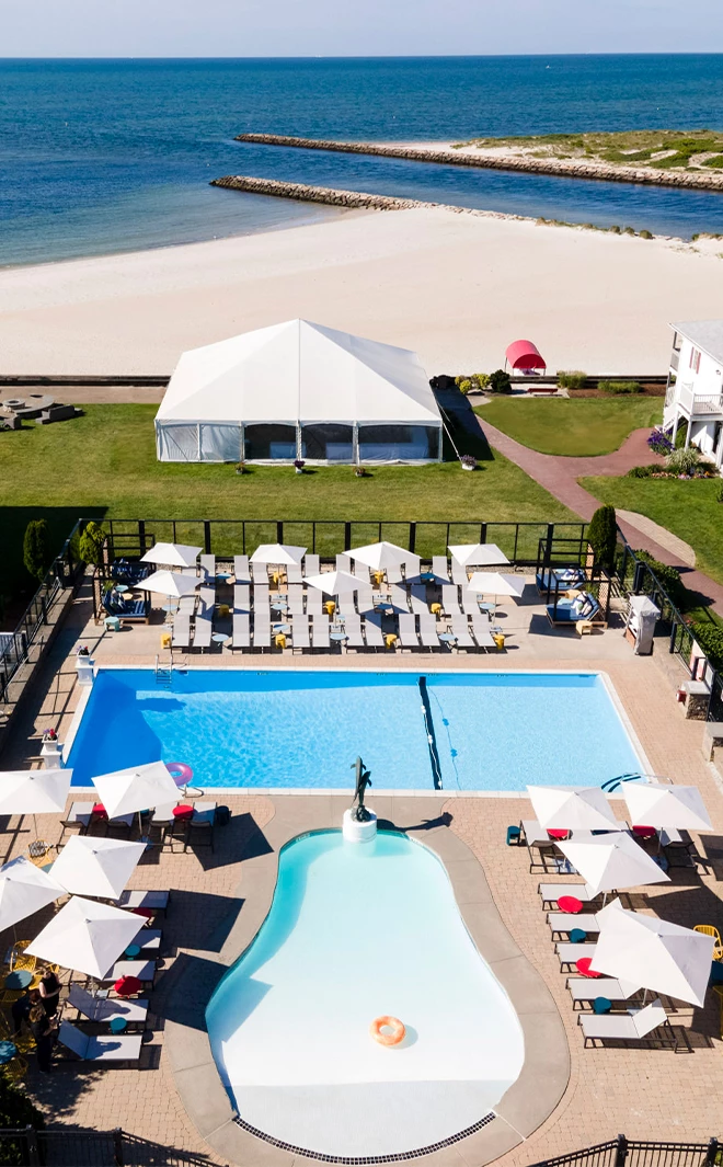 a swimming pool and a white tent next to a beach
