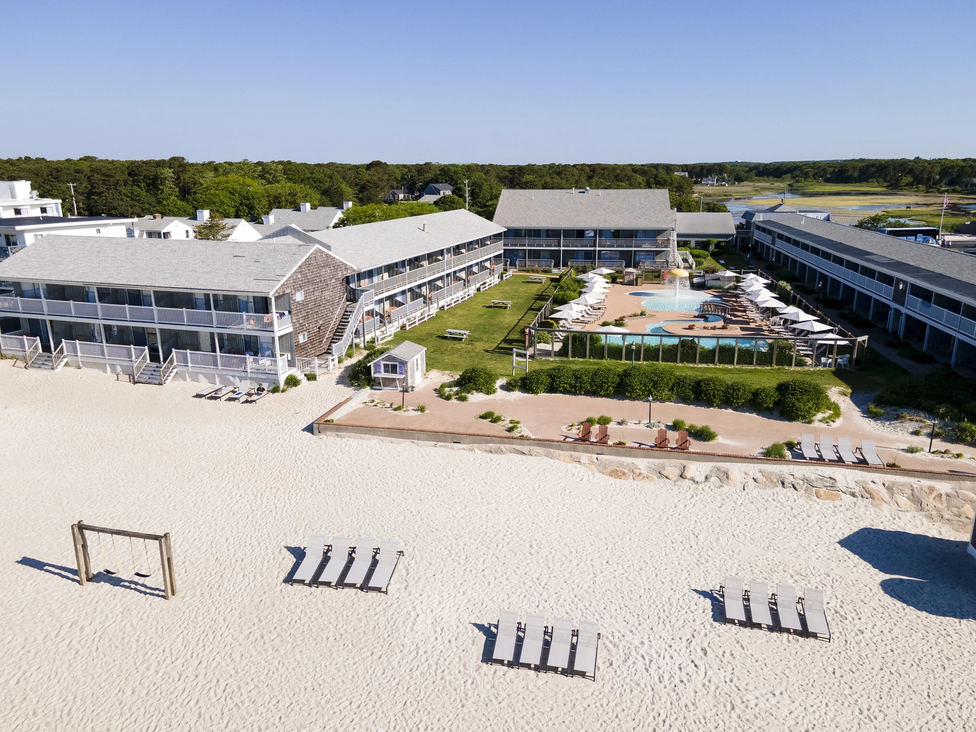 a beach with a hotel and a pool