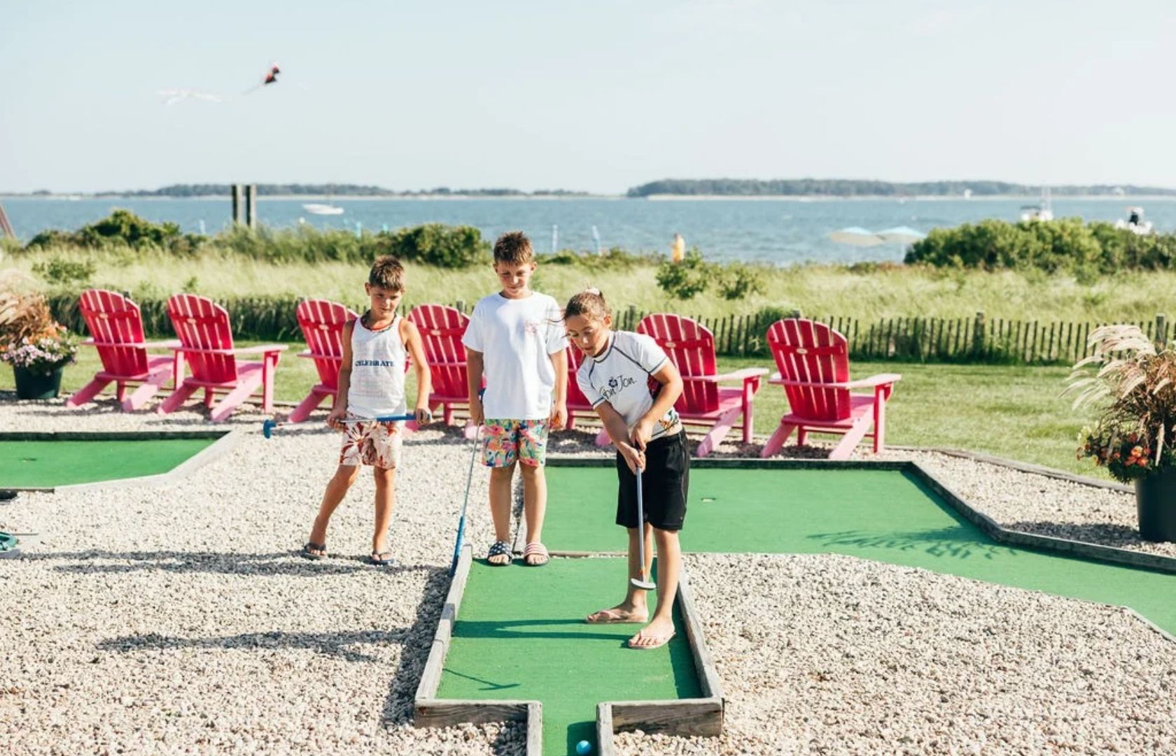 a group of kids playing mini golf