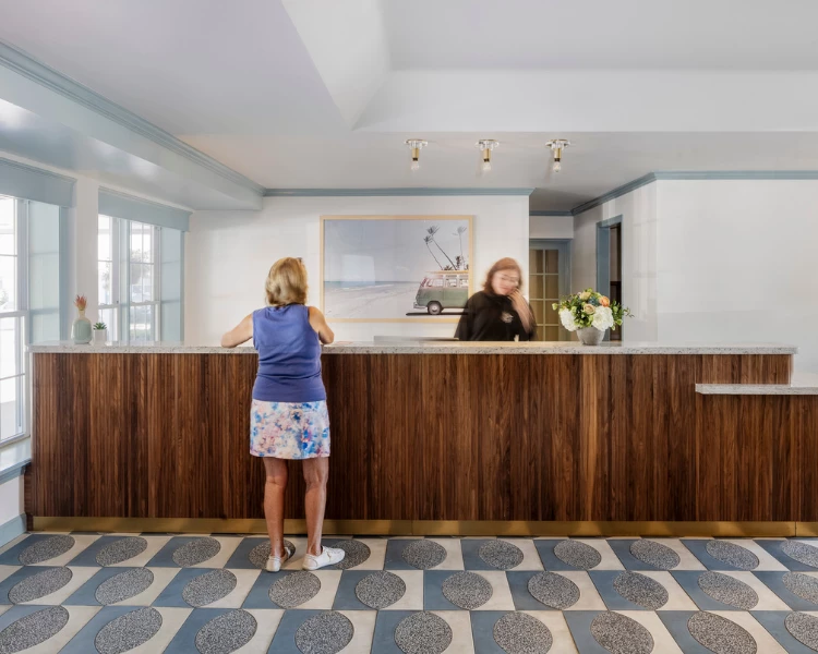 a woman standing at a counter in a hotel