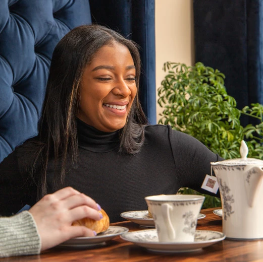lady sitting at table enjoying her coffee and pastre