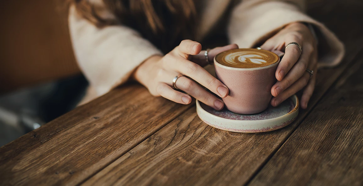 a person holding a cup of coffee