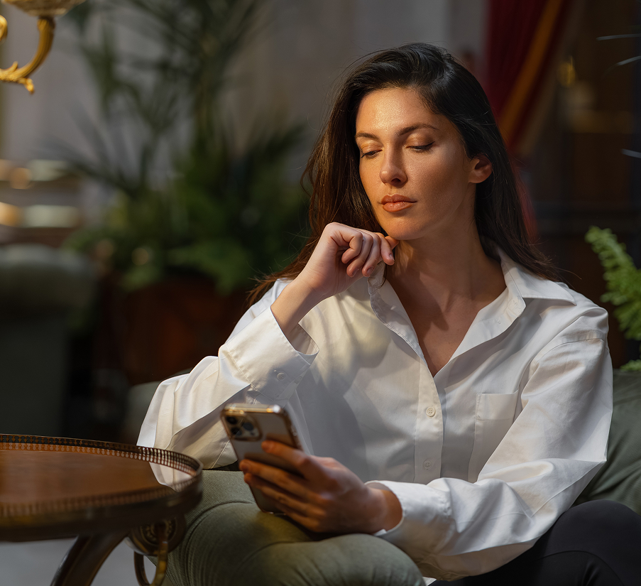 a woman sitting in a chair looking at her phone