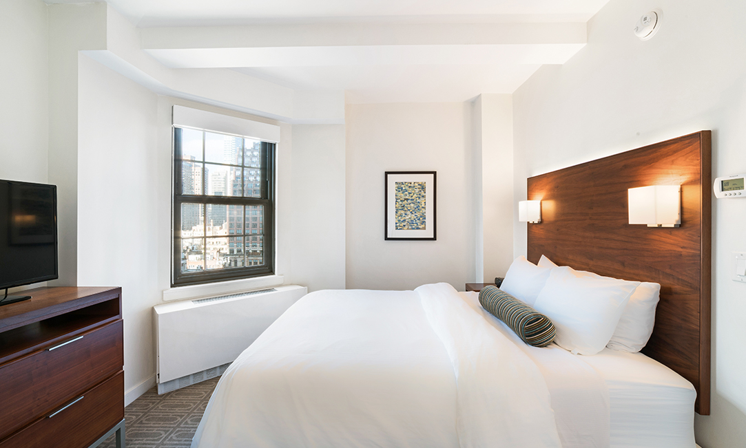 a bed with a wood headboard and a window