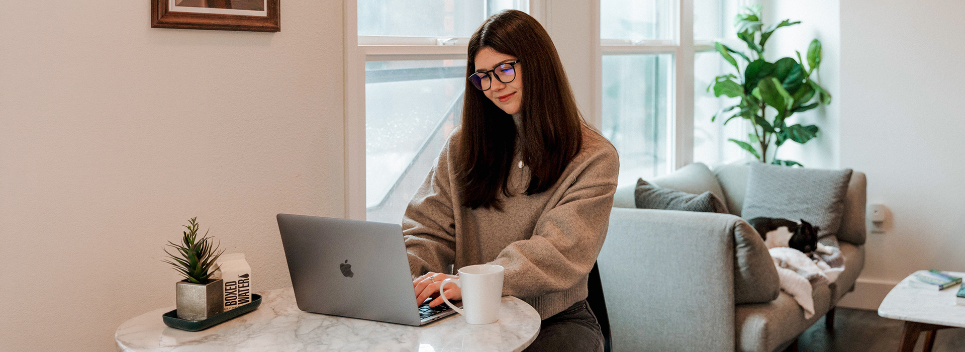 a woman sitting at a table with a laptop