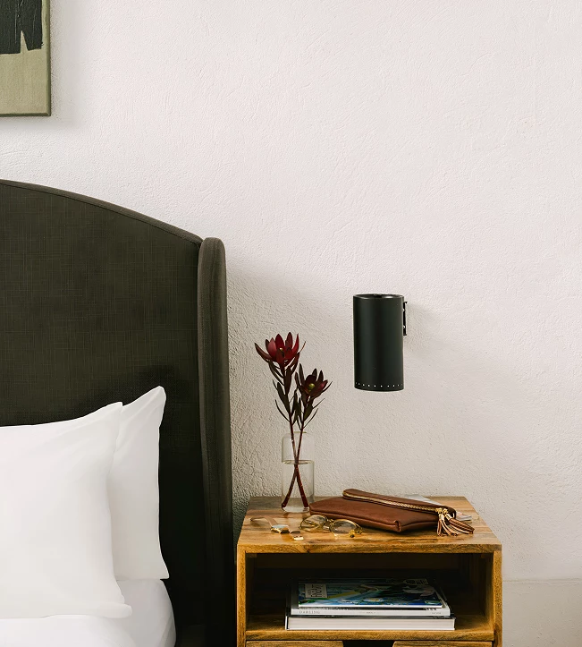 a nightstand next to a bed
