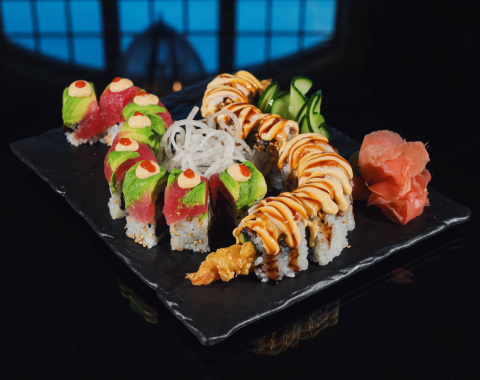 a plate of sushi on a black surface