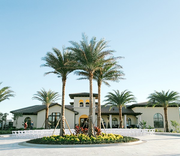A large building with a courtyard and palm trees.