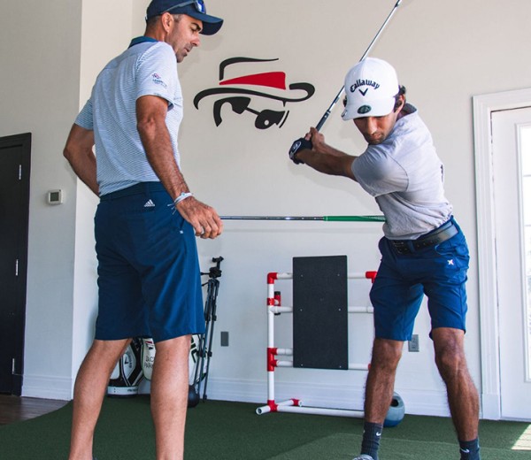 two men playing golf in a room