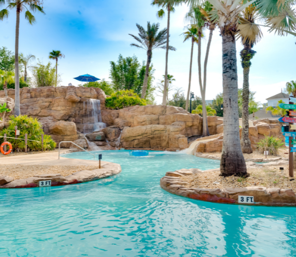 A pool with a waterfall and palm trees