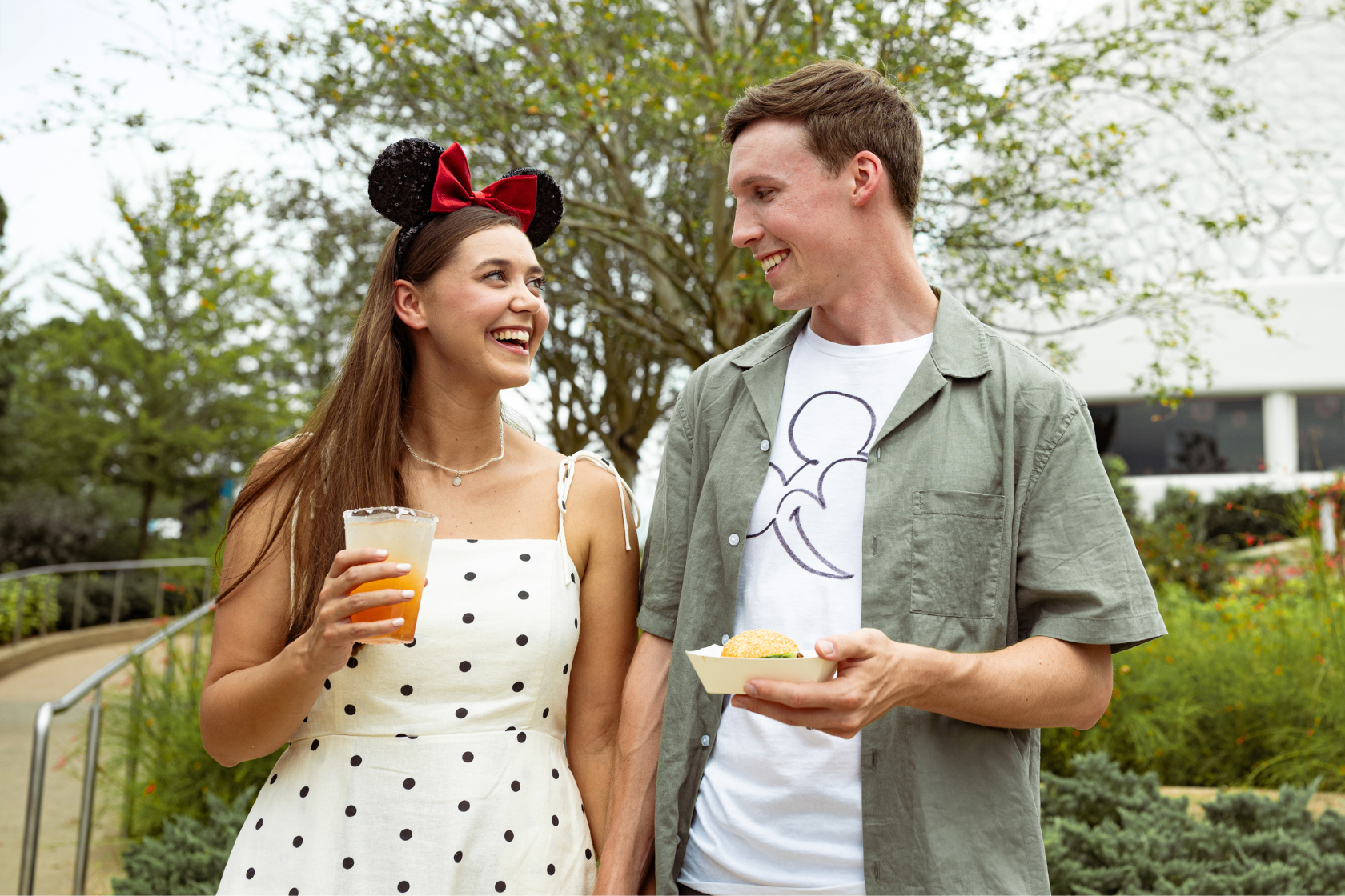 a man and woman holding food and drinks