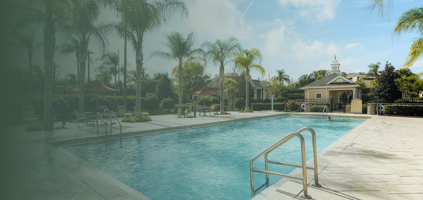 a swimming pool with palm trees and a building