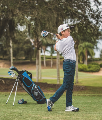 a boy swinging a golf club