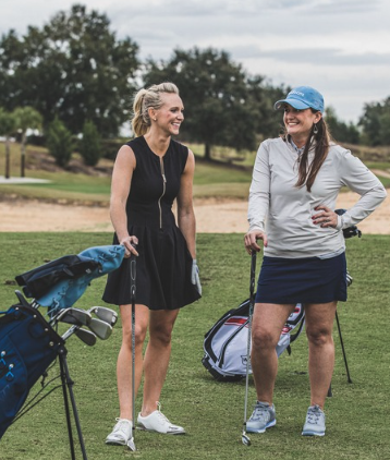 a group of women standing on a golf course