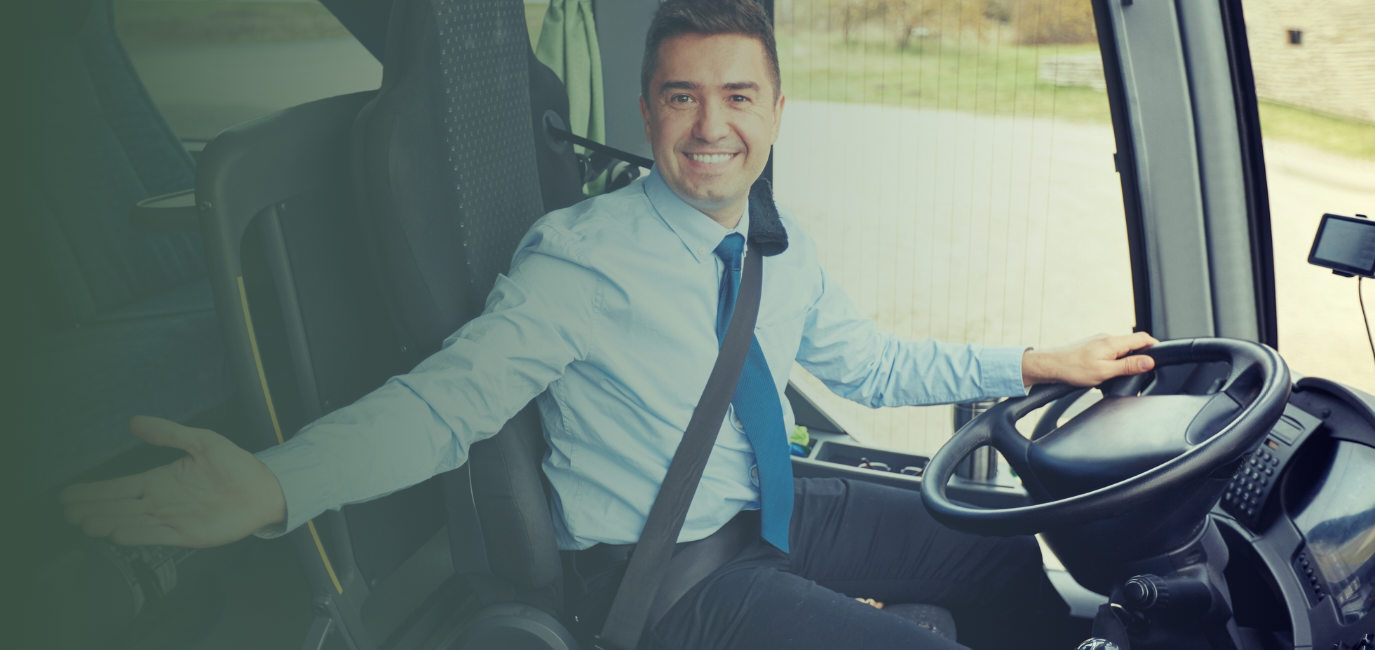 a man in a blue shirt and tie sitting in a bus