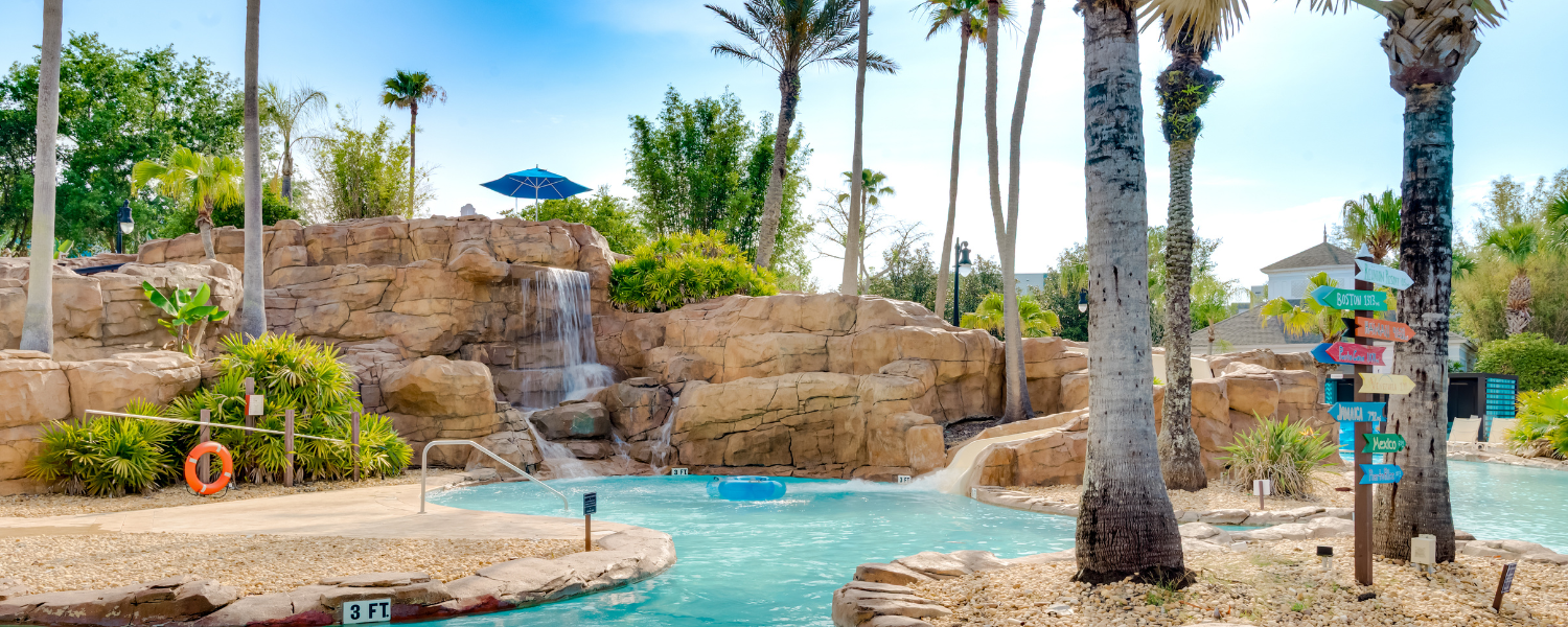 a pool with a waterfall and palm trees
