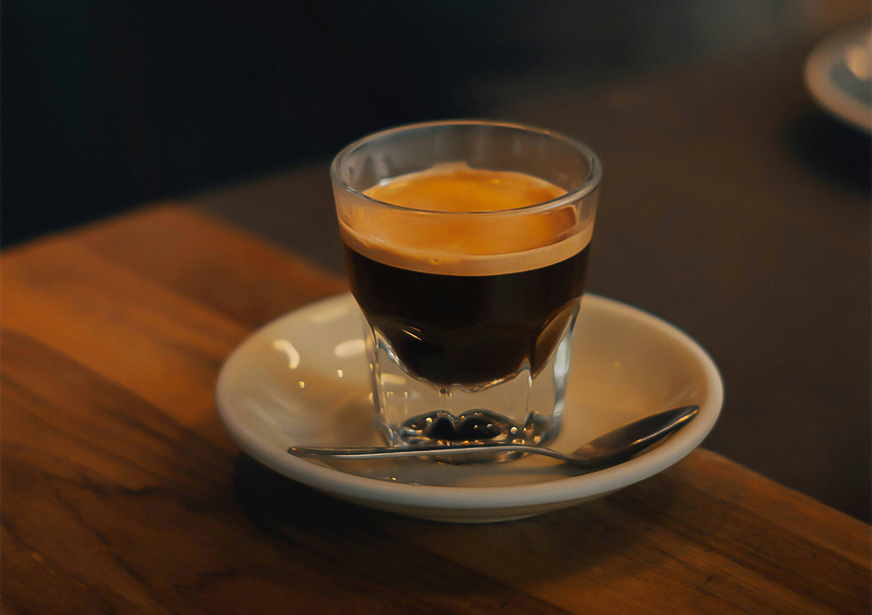 a glass of liquid on a plate