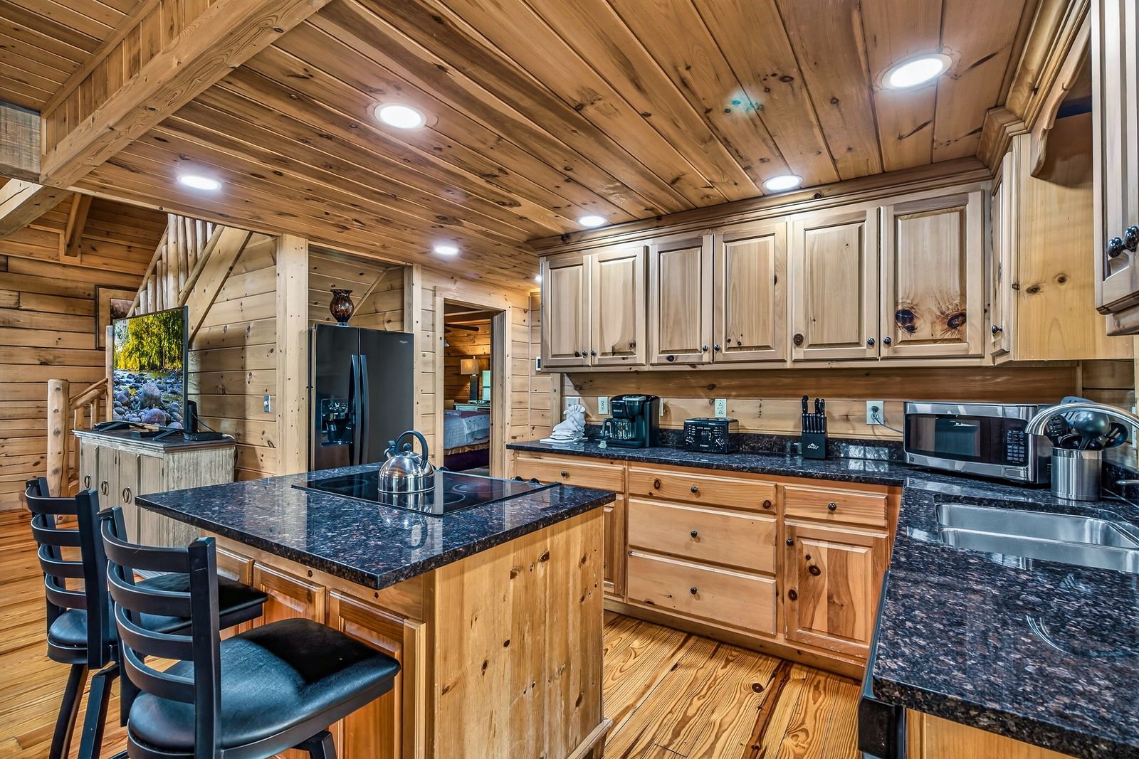 a kitchen with a black granite counter top and a black refrigerator
