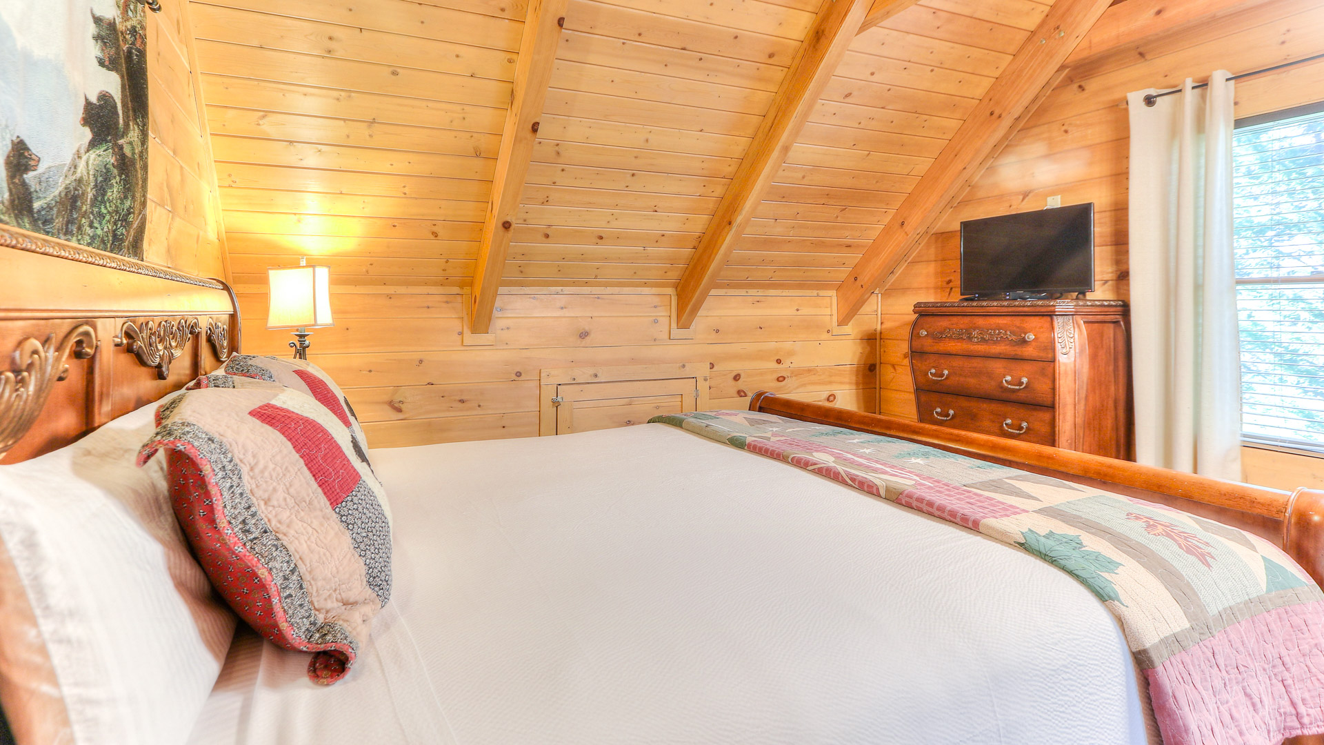 a bed in a room with a wooden ceiling
