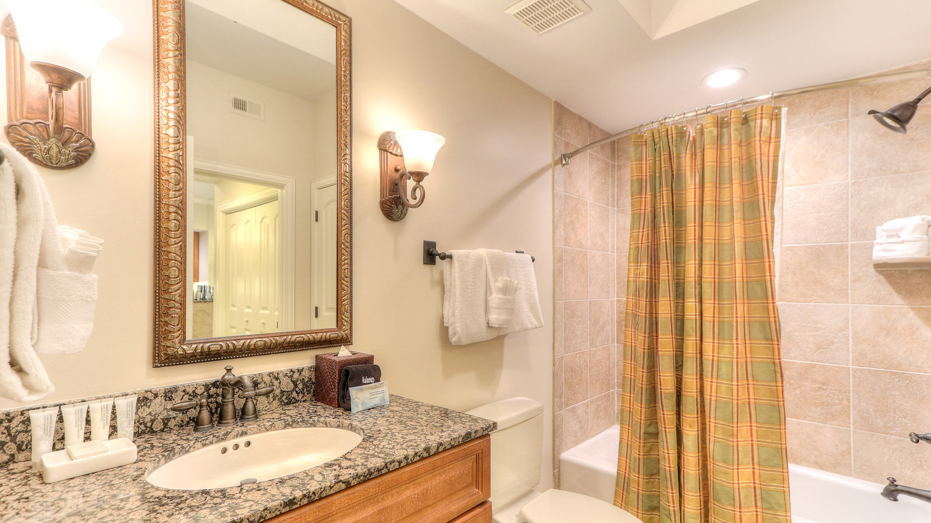 a bathroom with a marble countertop sink toilet and shower