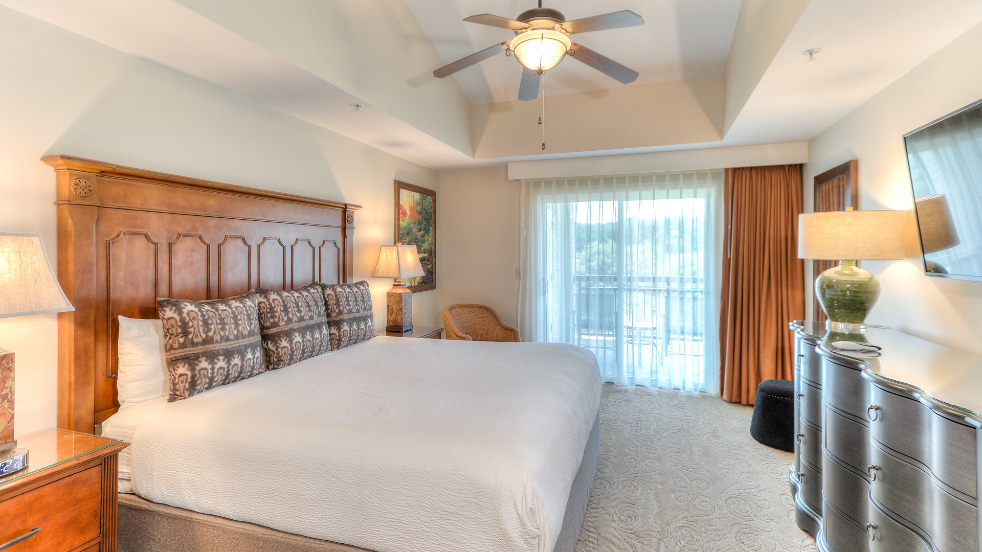 a bedroom with a large bed and a ceiling fan