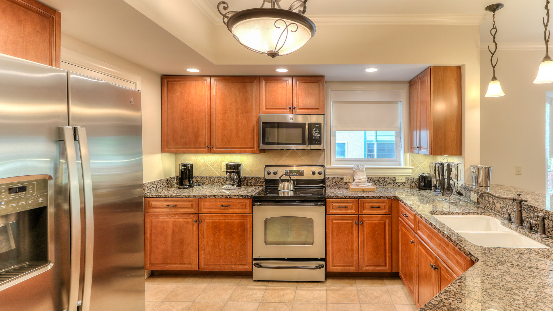 a kitchen with granite counter tops and a light fixture